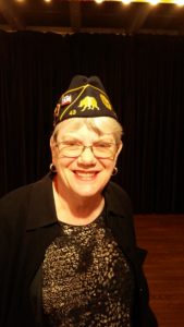 A young woman in military attire wearing a hat.