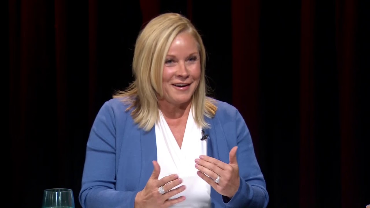 A woman in blue jacket talking to someone.